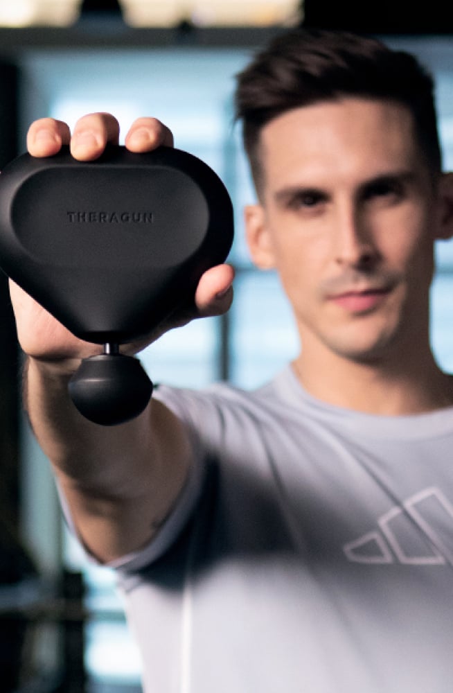 Cody Rigsby posing with Theragun mini device