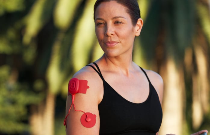 woman using power dot on upper arm