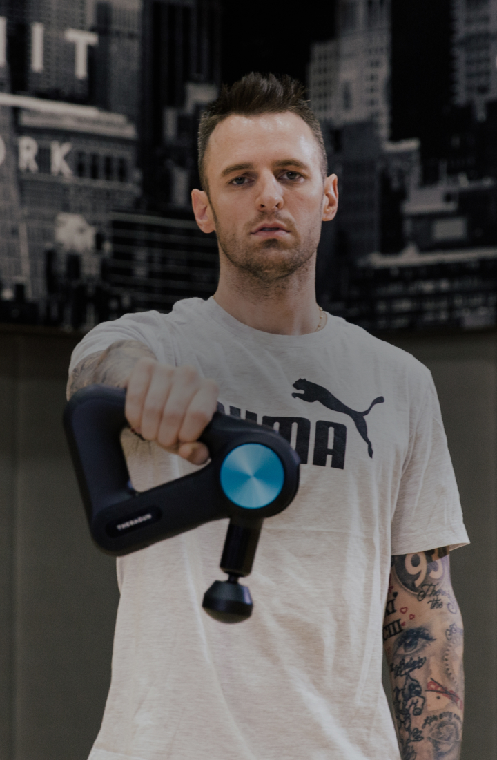 Chris Brickley posing with Theragun PRO Device